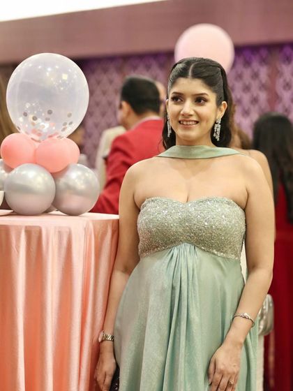 A personal moment from my baby shower, wearing a custom-made strapless gown in a soft mint green. The empire waistline and flowing fabric are perfect for accommodating a bump at a formal event, proving that maternity occasion wear can be both stunning and comfortable.