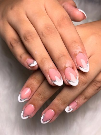 A classic French manicure gets a touch of glam with a fine line of silver glitter tracing the smile line for an elegant sparkle.