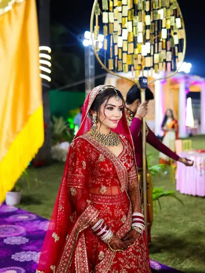A picture-perfect moment as the bride makes her grand entrance. Her classic red lehenga is paired with a timeless makeup look that radiates confidence.