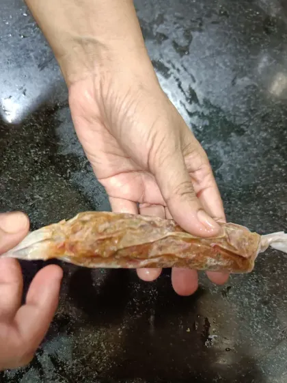 Each sausage is carefully wrapped by hand. This process ensures they hold their shape and cook evenly, locking in all the savory flavors.