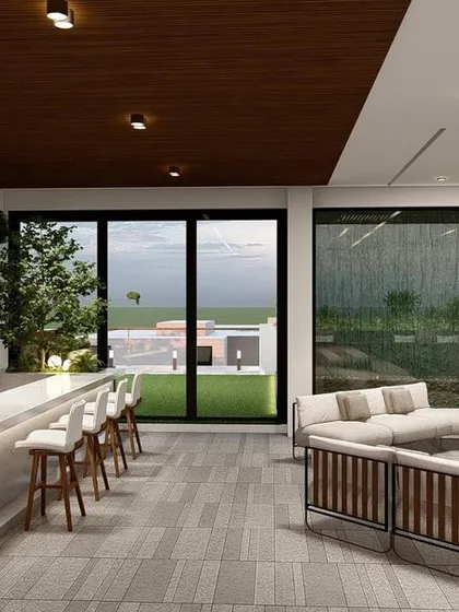 Another perspective of the covered lounge in Punjabi Bagh, showing the seamless flow from the kitchen and bar to the seating area and the view beyond.