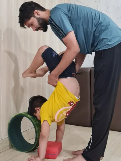 Another angle showing how we use props and hands-on assistance to help our little yogis achieve poses they might not be able to on their own, fostering a sense of accomplishment.