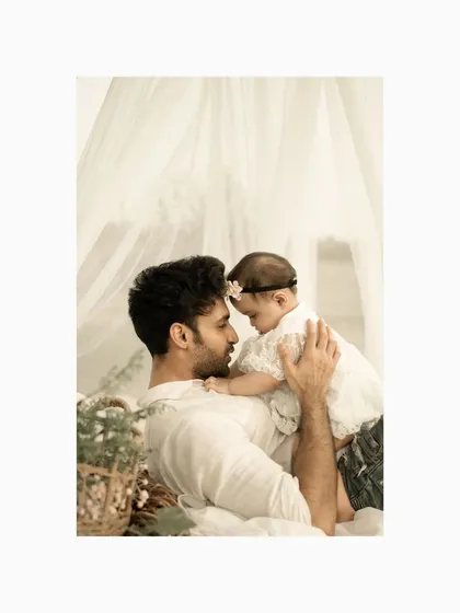 A father and his baby daughter share a tender moment, their faces close together. This intimate outdoor portrait captures the deep connection and love between a dad and his little girl.