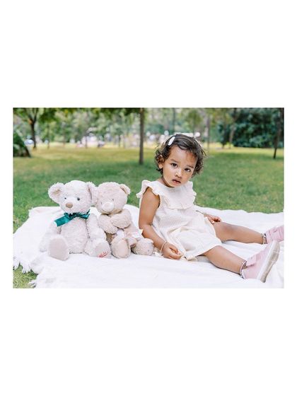 A little girl and her teddy bears on a picnic blanket. It's always a joy to reconnect with families for their yearly photoshoots.