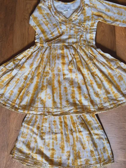 For your little girl who loves to twirl! This yellow and white Angarkha set is made from the softest cotton with just a hint of gold gota trim for that festive sparkle. It’s a traditional style made practical for modern kids who need to move.