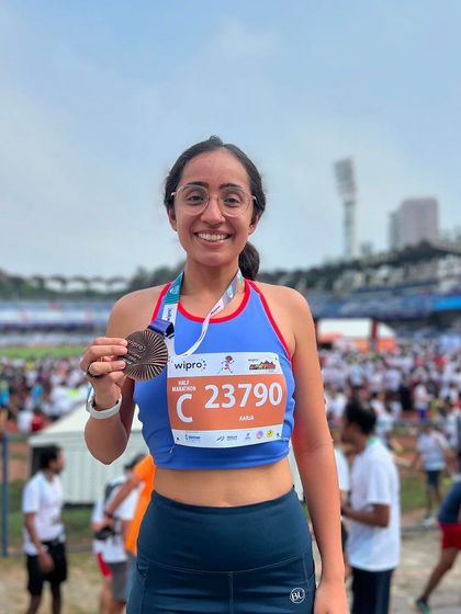 Holding my podium-finish medal from my first half marathon. This photo represents months of dedication and the joy of achieving a goal that once felt impossible.