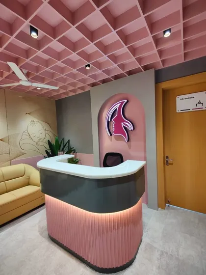 The reception desk at Life Care Clinic, featuring a custom design with fluted paneling and integrated lighting. The clinic's logo is prominently displayed, and a subtle wall mural in the background adds a soft, artistic touch to the space.