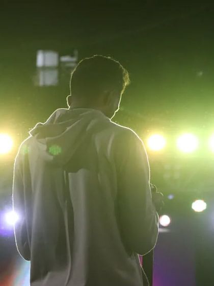 A silhouette against the green stage lights during a DJ night, capturing the cool, electric vibe.