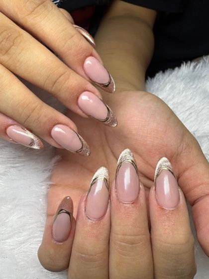 A modern and chic take on the French manicure, these almond-shaped nails feature a sheer base with a delicate gold and black double outline.