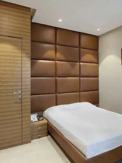 This bedroom features a fully upholstered wall panel headboard in a rich brown leatherette. It’s a modern and comfortable design that adds texture and warmth to the room, and I can create it in any size or configuration.