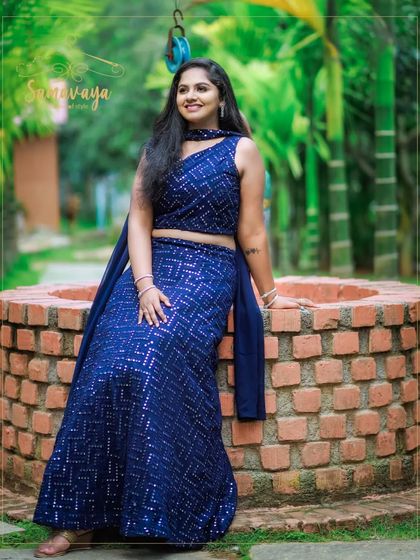 A relaxed pose by a brick well, this photo combines modern fashion with rustic charm for a unique outdoor portrait.