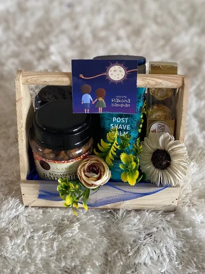 A thoughtful Rakhi hamper curated especially for a brother. This gift set includes men's grooming products like post-shave balm, paired with delicious Ferrero Rocher chocolates and gourmet nuts, presented in a rustic wooden crate.
