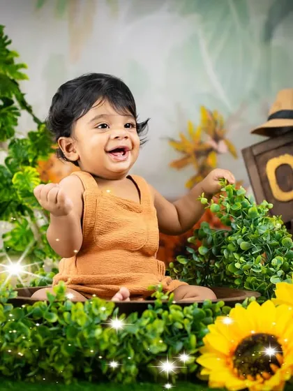 A smile that says everything! This little explorer is having a great time in our jungle-themed setup, complete with lush greenery and sunflowers.