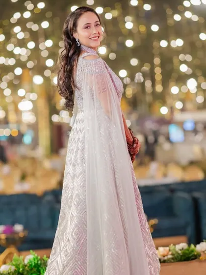 A full-length shot of the bride in her dreamy, silver-grey lehenga. The makeup is elegant and understated, letting the outfit and the bride's natural beauty shine.
