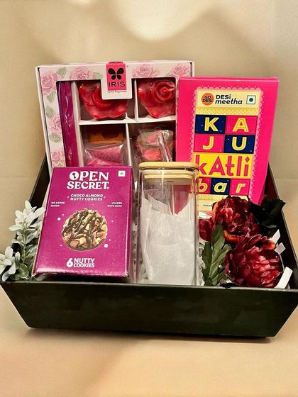 A modern festive hamper in a sleek black tray. This Diwali gift includes a mix of traditional sweets like Kaju Katli and modern snacks like nutty cookies.