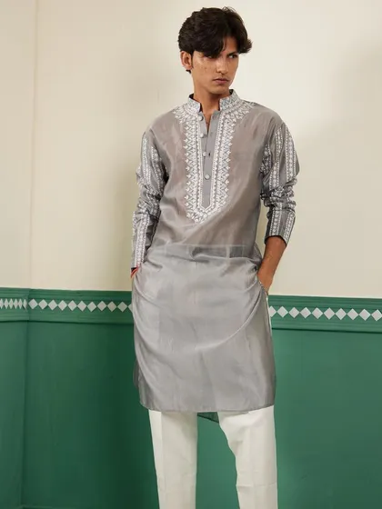 We believe in the quiet luxury of fine fabrics and detailed craftsmanship. This pearl grey kurta is crafted from lustrous Chanderi silk and features intricate Resham and silk thread embroidery on the placket and sleeves, offering a sophisticated look for any celebration.