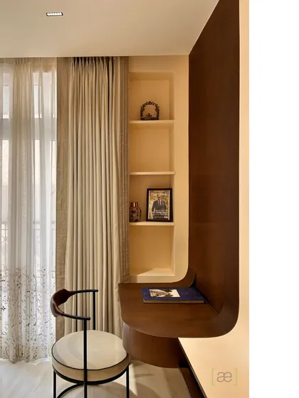 A custom-designed study nook with a curved wooden desk and built-in shelves. This space-efficient solution provides a functional workspace without compromising on style.