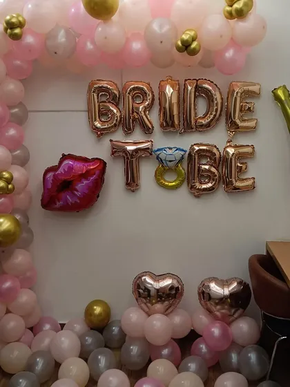 I also offer simpler wall decorations for bridal showers. This setup uses "BRIDE TO BE" foil letter balloons, a partial balloon arch, and themed foil balloons like lips and a diamond ring to create a festive corner at home.