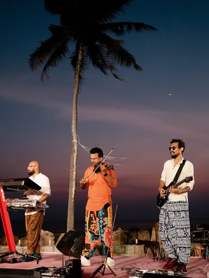 Entertainment is crucial for setting the mood. Here, a live band performs against a stunning sunset backdrop at a beachside wedding, creating a serene and magical atmosphere.