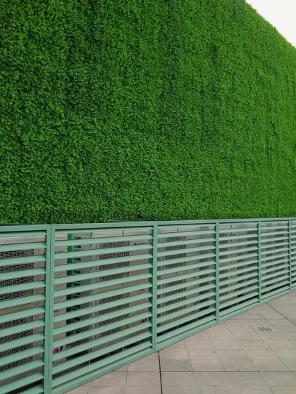 This large-scale commercial installation showcases a massive artificial green wall, creating a striking and modern exterior facade. The high-quality, UV-resistant turf ensures the building stands out with vibrant, year-round greenery, perfect for corporate offices or public buildings in Bangalore.
