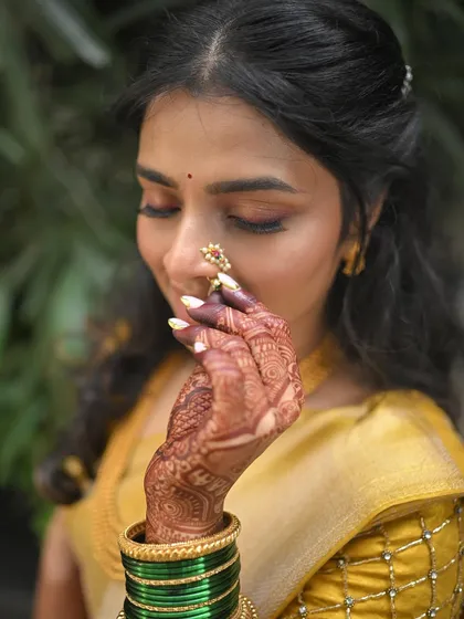 A close-up on the details for an engagement look: the intricate henna, the Maharashtrian nath, and the soft eye makeup.