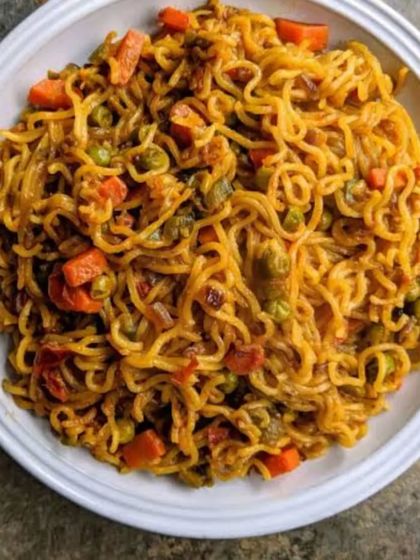 A bowl of my special street-style Maggi, cooked with chopped carrots, peas, and a blend of spices to elevate the classic instant noodles. It's the ultimate comfort food for any time of the day or night.