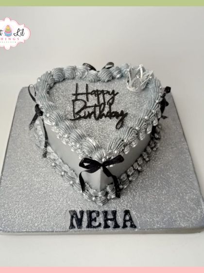 A chic and shimmering silver heart-shaped cake for Neha's birthday. The vintage piping and small black bows add a touch of gothic elegance.