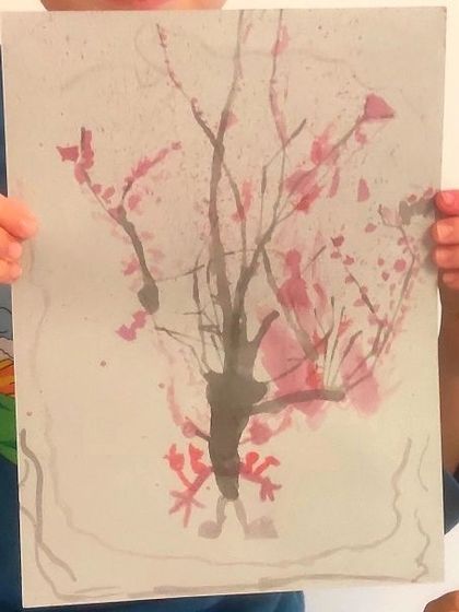 A duplicate image of a delicate cherry blossom tree, where ink was blown across the paper to create natural-looking branches.