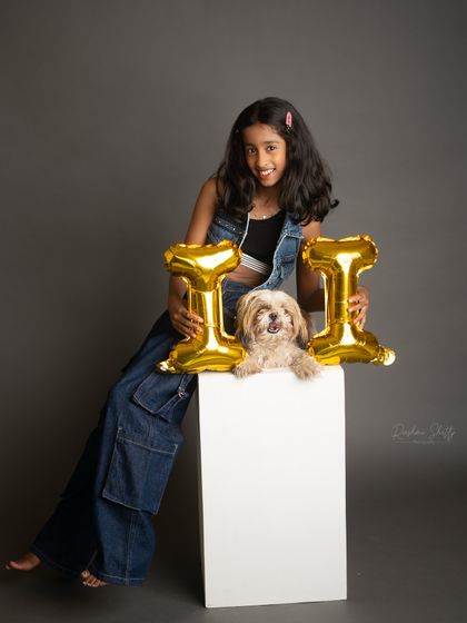 Celebrating eleven with her furry friend. The contrast of the metallic balloons and the monochrome photo creates a modern and fun birthday portrait.