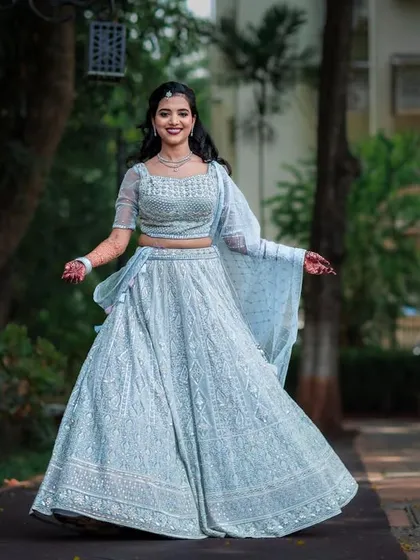 A joyful, twirling portrait of the bride-to-be in her beautiful light blue lehenga.