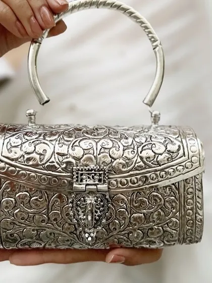 I believe accessories should be timeless works of art. This intricately carved German silver clutch is a statement of pure elegance, perfect for weddings and festive evenings. It is handcrafted to be an heirloom piece you will treasure forever.