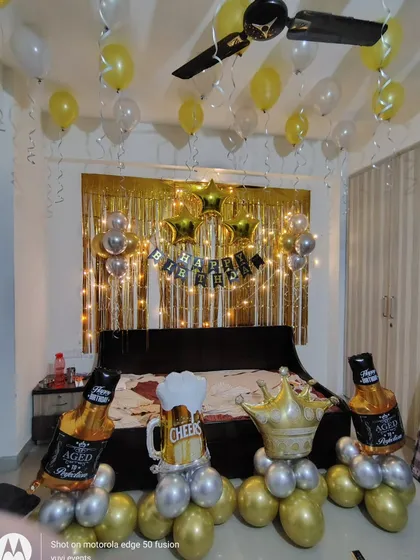 The birthday setup with "Aged to Perfection" and "Cheers" themed props.