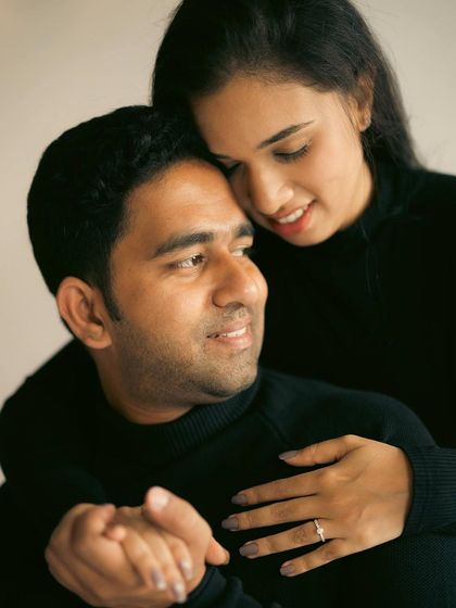 A warm, close embrace during an indoor couple shoot. The focus is entirely on their expressions and the comfort they find in each other.