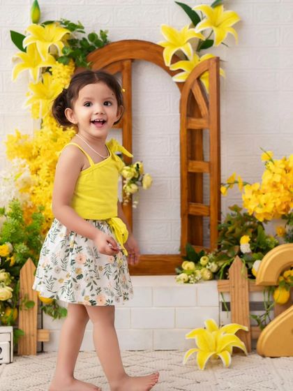A sunny second birthday. The bright yellow theme and the little girl's happy energy make this a joyful and vibrant celebration.
