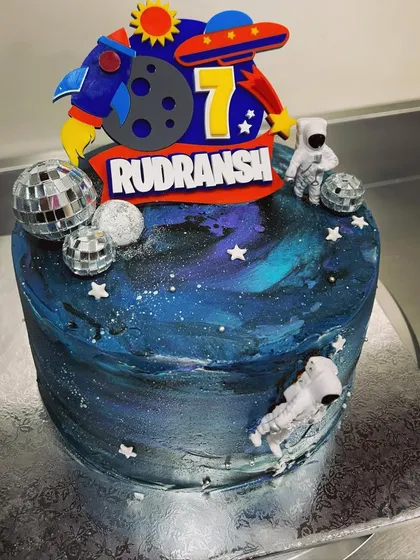 Need some space? This galaxy-themed cake is perfect for a young astronaut's birthday. It features deep blue and purple buttercream, disco ball planets, and an astronaut topper for an out-of-this-world celebration.