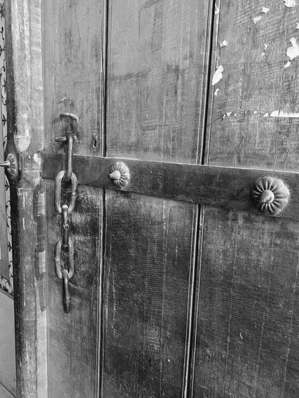 Another detail of a rustic, chain-locked wooden door, showcasing the textures of the old city.