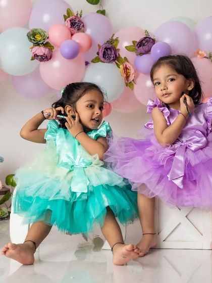 These twin sisters are striking a pose. Capturing the unique bond and playful dynamic between twins is one of our favorite things to do.