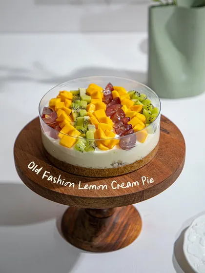 Our Old Fashioned Lemon Cream Pie, topped with a vibrant mix of seasonal fruits including mango, kiwi, and grapes.