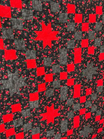 A detailed shot of the red and black star quilt.