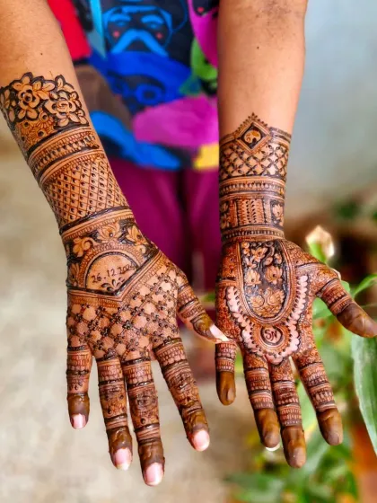 This engagement mehendi features a mix of styles, with a date on one hand and a traditional mandala on the other. The arms are covered in detailed line work and floral cuffs.