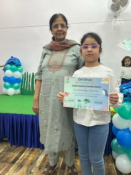 A student and her grandmother posing with her certificate. The support from family members makes these events even more special for the children.