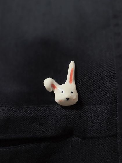 A close-up of a whimsical bunny lapel pin from my collection. This small, hand-painted piece adds a touch of personality to any jacket or bag.
