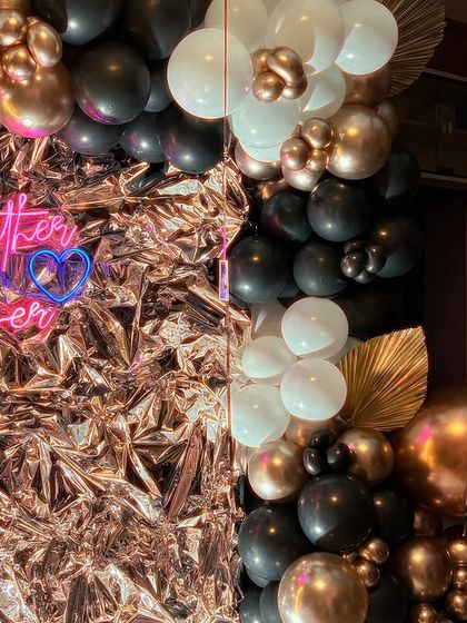 A close-up of the foil backdrop and neon sign. The crinkled foil catches the light beautifully, creating a dynamic and eye-catching effect.