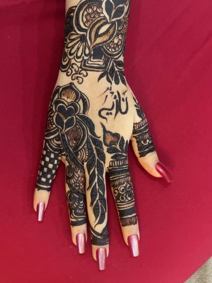 A modern Arabic design incorporating a feather motif and the name 'Nadia' in calligraphy.