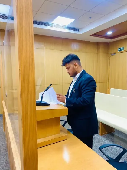 Reviewing case notes at the podium before addressing the court. Preparation and attention to detail are the foundations of a powerful legal argument.