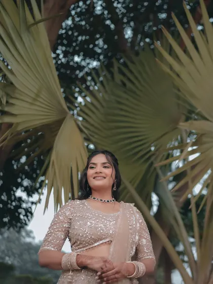 A beautiful outdoor portrait of Pallavi, with lush palm trees creating a natural and serene background.