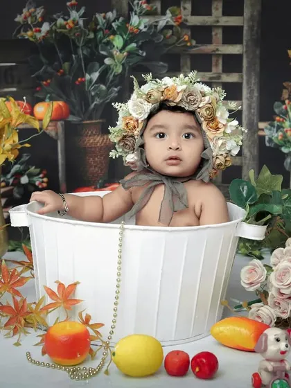A classic toddler bathtub shoot with a rustic, autumnal feel. The baby is surrounded by colorful leaves and flowers, creating a charming and timeless portrait.