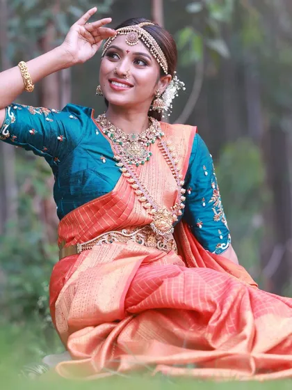 A seated pose in a natural, outdoor setting. This shot from our bridal saree collab has a calm and graceful feel, perfectly matching the elegance of the attire.