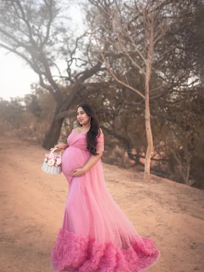 Captured during the golden hour, this outdoor portrait is all about soft, dreamy romance. The flowing pink gown from my client wardrobe and the rustic natural setting create a whimsical, fairytale-like atmosphere, perfect for a romantic maternity photoshoot.