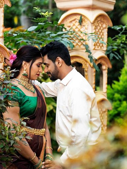 An intimate moment between a couple, framed by the lush greenery and traditional architecture of our garden sets.